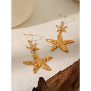 Detailed close-up of double-layer starfish earrings with sparkling rhinestones, gold finish.