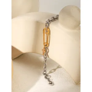 Stainless steel mixed-color chain bracelet with paperclip charm and crystal cross detail.
