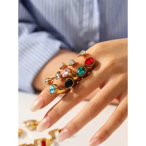 Close-up detail of multi-color teardrop zircon rings in gold-toned stainless steel for women.