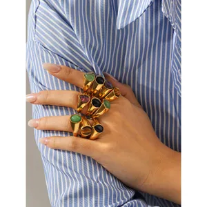 Close-up view of stacked hexagonal natural stone rings in gold titanium steel, stylish detail shot.