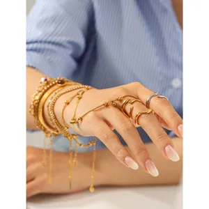 Detailed shot of multi-layer stainless steel gold bracelets and trendy irregular rings.
