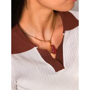 Detail view of the elegant red gourd pendant necklace on model, stylish titanium steel jewelry.