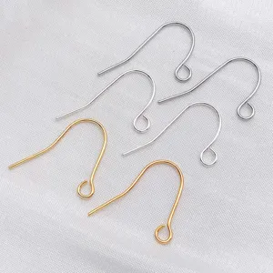Gros plan détaillé montrant des crochets de boucles d'oreilles DIY en métal sur du tissu.