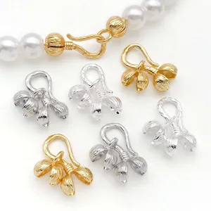 Close-up of gold and silver flower shaped jewelry clasp findings for DIY necklace bracelets.