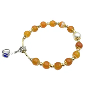 DIY beaded bracelet accessory featuring orange beads, gold spacers, pearl, and crown charm.