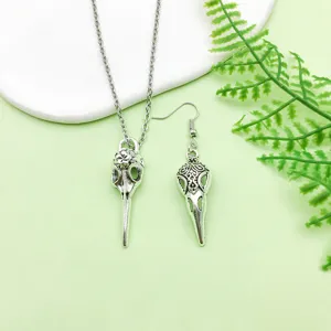 Retro antique silver alloy bird skull pendant necklace and matching earring detail close view.