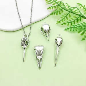 Detail shot of antique silver bird skull pendant DIY jewelry accessories style.