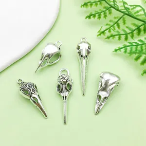 Close-up details of antique silver bird skull pendants, perfect for Halloween DIY jewelry making.