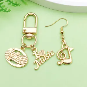 Detailed shot of gold tone music note and heart charm pendants for DIY jewelry making.