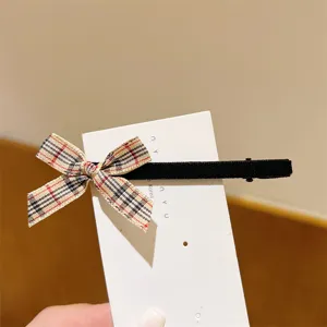 Close-up detail of a sweet plaid ribbon bow hair clip with black velvet, perfect for cute daily wear.