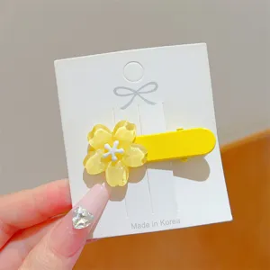 Close-up shot of the yellow jelly flower duckbill hair clip detail on white paper card.