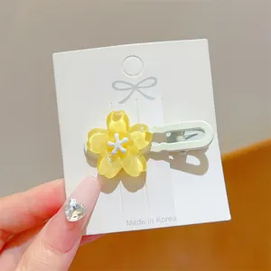 Close up of a sweet jelly yellow flower hair clip, resin floral design with duckbill clip.