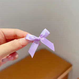 Delicate purple ribbon bow hair clip detail, sweet style mini hair accessory for cute styling.