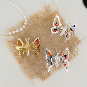 Gros plan détaillé de pinces à cheveux papillon en métal avec perles sur toile de jute.