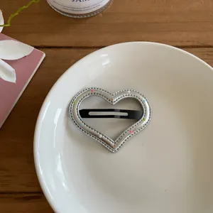 Primer plano detallado de horquilla de corazón de cuero PU plateado con puntos de colores.