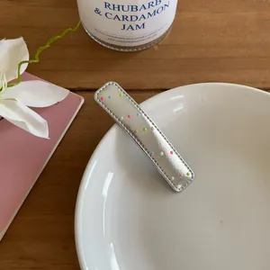 Pinza para el pelo de cuero PU plateado con lunetos de colores, detalle elegante.