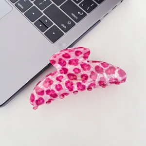Gros plan détaillé d'une pince à cheveux rose léopard en acétate, élégant accessoire de coiffure.