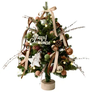 Mini kerstboom tafeldecoratie met warme verlichting, linten en feestelijke ornamenten.