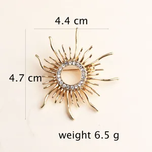 Vista dettagliata della spilla a sole dorata con strass scintillanti, elegante accessorio per abito.