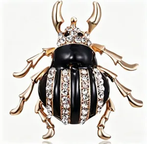 Close-up detail of rhinestone beetle brooch showing shiny crystal and gold alloy craftsmanship.