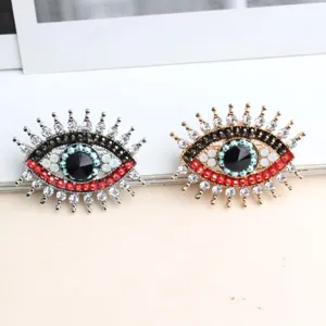 Vista dettagliata della spilla con strass malocchio, cristalli brillanti e design rétro.