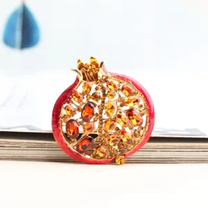 Squisita spilla melograno con smalto rosso e cristalli ambra per eleganti accessori.