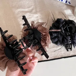 Vue détaillée de la pince à cheveux élégante en plume et fleur, design chic pour coiffure.