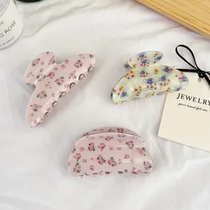 Vue détaillée de pinces à cheveux en acétate floral avec de jolies motifs et des dents solides.