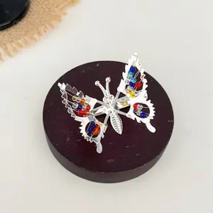 Pince a cheveux papillon argente avec des perles colorees, accessoire de coiffure elegant.