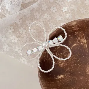Detalle de pinza de pelo de perlas y diamantes, accesorio de mariposa estilo francés para mujer.