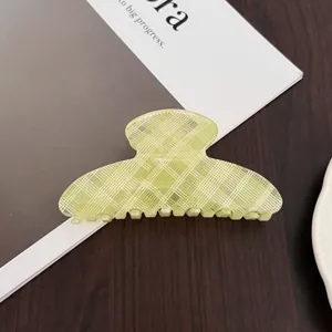 Gros plan détaillé d'une pince à cheveux à carreaux vert clair, accessoire minimaliste.