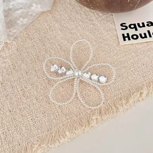 Primer plano de pinza de pelo con flor de perla y strass, accesorio de moda elegante.