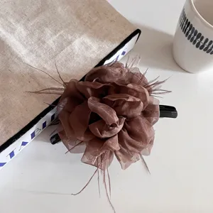 Pince a cheveux fleur de plume marron vue detaillee, accessoire elegant pour femmes.