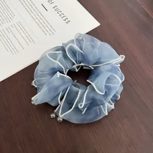 Coletero de organza azul con borde de volantes blancos y colgante de cristal para moño bajo.