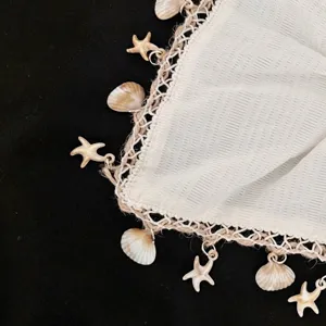 Gros plan détail style vacances avec coquillage et étoile de mer en coton dentelle.