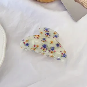 Gros plan détail de la pince à cheveux élégante en acétate floral, beau motif délicat.