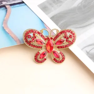 Elegant red rhinestone butterfly brooch crafted with shiny gold tone metal alloy.