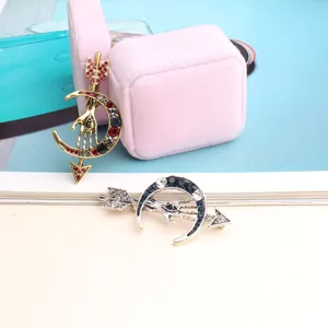 Detailed close-up of retro hand and moon arrow rhinestone brooch, exquisite metal craftsmanship.