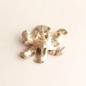Detailed back view of the elegant gold tone metal flower brooch showing secure pin clasp.