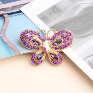 Detailed view of 3D hollow butterfly brooch with purple rhinestones and iridescent center stone.