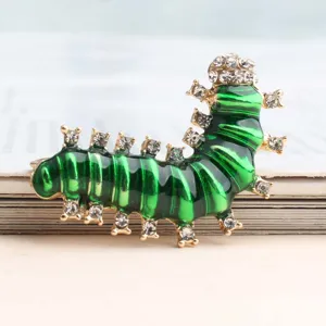 Gedetailleerde close-up van een schattige groene emaillen rupsbroche met sprankelende strass.