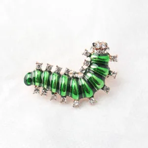 Detailopname van de groene strass rups broche, met prachtige emailafwerking en schitterende stenen.