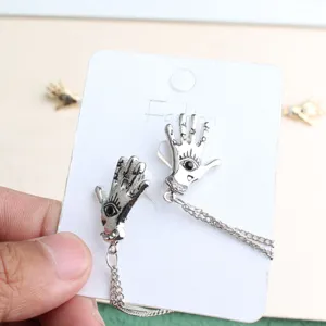 Punk vintage palm brooch lapel pin detail shot showing unique gothic hand design and chain.