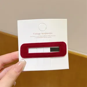 Velvet barrette detail view, elegant burgundy hair clip close-up shot on white card.