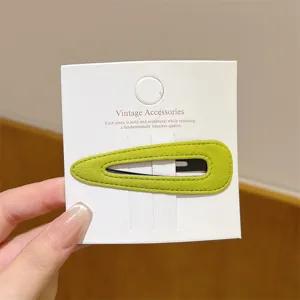 Detail shot of green velvet hair clip on white card, soft texture and elegant daily wear accessory.