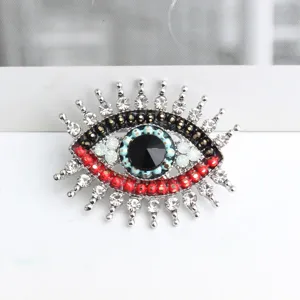 Primo piano dettaglio spilla strass malocchio vintage, design in cristallo brillante per donna.