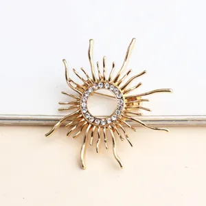 Primo piano della spilla dorata a forma di sole, metallo in lega con strass brillanti.