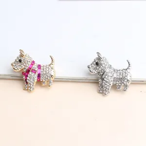 Detailierte Ansicht von zwei glitzernden Strass Hund Broschen in Gold und Silber.