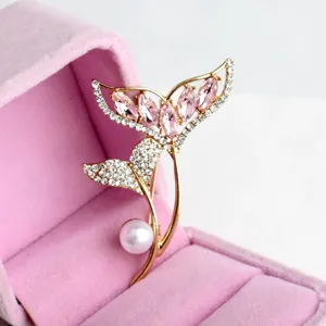 Exquisite detail shot of the elegant whale tail pearl brooch with pink crystals and rhinestones.