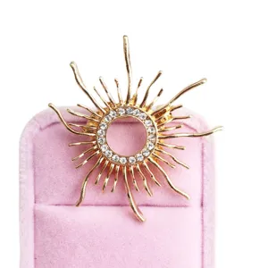 Spilla sole dorata con strass scintillanti, elegante accessorio vintage per vestito.